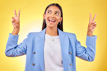 Image showing Fashion, peace sign and Indian woman on yellow background with smile, positive attitude and happy. Emoji, business and person in studio for hand gesture in trendy clothes, professional style and suit