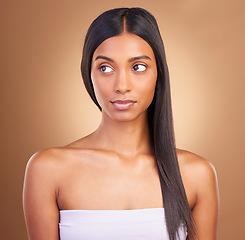 Image showing Keratin, hair care and skincare with face of woman in studio for beauty, salon treatment and texture. Shampoo, health and thinking with model on brown background for glamour, shine and hairstyle