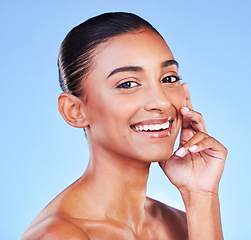 Image showing Natural beauty, happy woman and face, skin and glow with wellness and dermatology isolated on blue background. Hand touching cheek, skincare and shine with collagen, manicure and portrait in studio