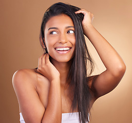 Image showing Beauty, smile and woman in studio for hair, growth or texture and shine against a brown background space. Haircare, cosmetics and face of female model happy for shampoo, mask or volume and results