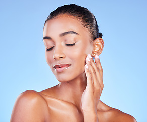 Image showing Woman, touching face and natural beauty, skincare and cosmetic care isolated on blue background, Indian model with satisfaction, wellness and calm, zen and dermatology with skin glow in a studio