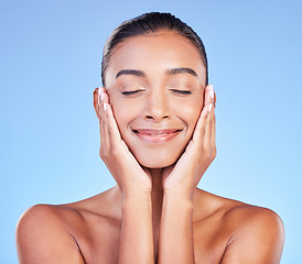 Image showing Skincare, peace and hands on face with happy woman in studio with blue background and dermatology or cosmetics. Indian, model and happiness with natural skin and healthy facial glow or beauty care