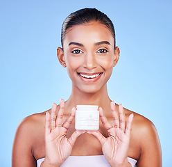 Image showing Skincare, cream and product with portrait of woman in studio for beauty, facial or moisturizer. Spa treatment, health and collagen with face of person on blue background for makeup, glow or sunscreen