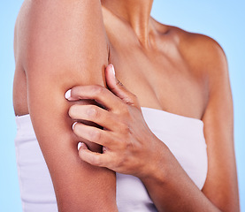 Image showing Arm injury, stress and hands of woman in studio with arthritis, osteoporosis or emergency on blue background. Shoulder, accident and lady person with joint pain massage for osteoarthritis relief