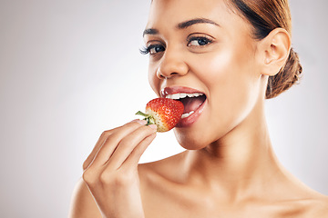 Image showing Woman, eating strawberry and skincare portrait, beauty or eco friendly product and natural cosmetics in studio. Happy person, face and red fruit for vegan makeup or dermatology on a white background