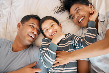 Image showing Funny, tickle and relax with family in bedroom for playful, morning and love from above. Care, support and wake up with parents and child in bed at home for weekend, positive and happiness together