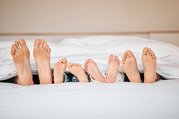 Image showing Sleeping, relax and feet with family in bedroom for calm, morning and love. Care, support and wake up with closeup of parents and children in bed at home for weekend, peace and resting together