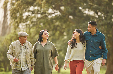 Image showing Love, walking and smile with big family in park for bonding, support and summer. Vacation, happy and holiday with people relax in grass field in nature for peace, generations or care together