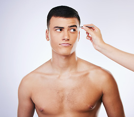 Image showing Man, tweezer and skincare with doubt and beauty treatment for epilation and wellness in studio. Male model, dermatology and hair removal tool for eyebrows pull and hand on face with white background