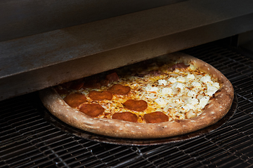 Image showing Preparing pizza in oven