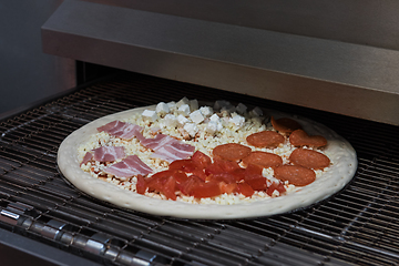 Image showing Preparing pizza in oven