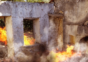 Image showing Disaster, damage and fire with house and smoke from danger, chaos accident and devastation. War, crisis and abandoned with broken building structure for grunge, construction and military attack