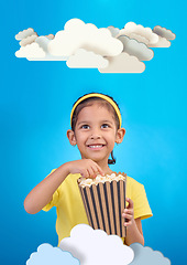 Image showing Paper, cloud and girl child with popcorn in studio for cinema, fantasy or creative space on blue background. Kindergarten, lesson and kid with snack for movie, learning or creativity and television