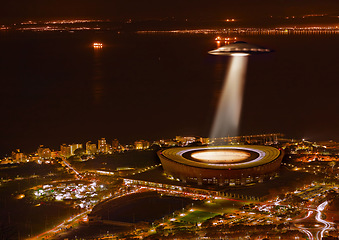 Image showing UFO, light and city in night, alien invasion and search with light on stadium in Cape Town. UAP ship, flying saucer and tractor beam in dark cityscape, metro or cbd for survey, inspection and flight