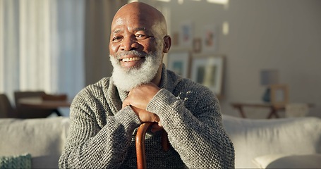 Image showing Happy, face and a black man with a cane on the sofa for support, medical help and retirement. Smile, house and portrait of a senior African person on the living room couch with a stick for walking