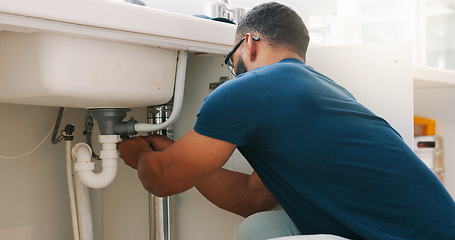 Image showing Plumber black man, kitchen and sink maintenance with tools, focus and pipe repair for drainage in home. Entrepreneur handyman, plumbing expert or small business owner in house for fixing water system