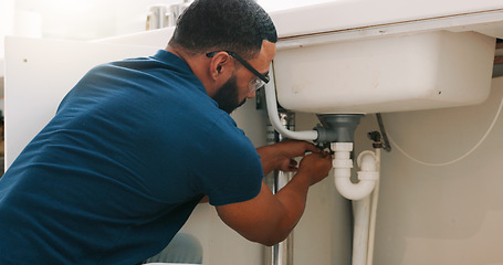 Image showing Plumber black man, kitchen and sink maintenance with tools, focus and pipe repair for drainage in home. Entrepreneur handyman, plumbing expert or small business owner in house for fixing water system