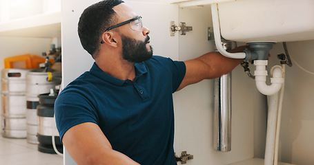 Image showing Plumber black man, kitchen and sink maintenance with tools, focus and pipe repair for drainage in home. Entrepreneur handyman, plumbing expert or small business owner in house for fixing water system