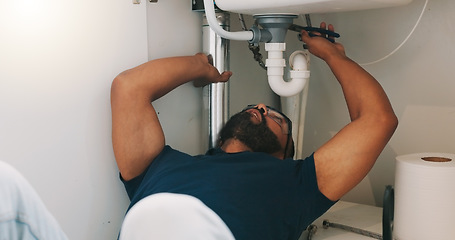 Image showing Plumber black man, kitchen and sink maintenance with tools, focus and pipe repair for drainage in home. Entrepreneur handyman, plumbing expert or small business owner in house for fixing water system