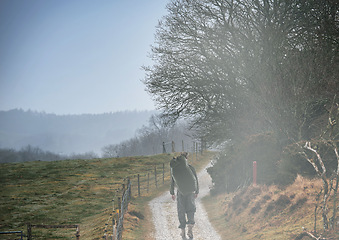 Image showing Nature, backpack and soldier walking on path, travel and journey outdoor on mockup space. Forest, bag and military man on road hiking in woods, countryside or trekking in camouflage on adventure.