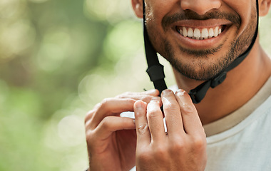 Image showing Hands, helmet and ready for cycling in forest for man, smile and buckle for training, adventure or transport. Guy, closeup and happy with ppe, countryside and preparation in woods, park or nature