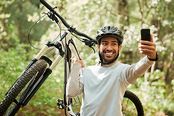 Image showing Man, bicycle and forest for selfie, smile and web for wellness, training and blog on adventure. Influencer guy, cycling and mountain bike for profile picture, memory or live streaming on social media