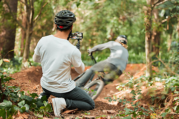 Image showing Man, bike and forest with photographer, speed and phone for race, cycling video or post on web blog. Guy, bicycle and recording for vlog, live streaming or social media in woods for outdoor sports