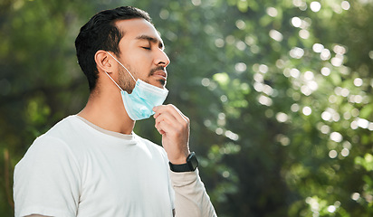 Image showing Relief, breathing and a man with a face mask in nature for fitness, running or exercise. Calm, mockup space and an Asian runner or athlete with covid and breathe after running in a park for cardio