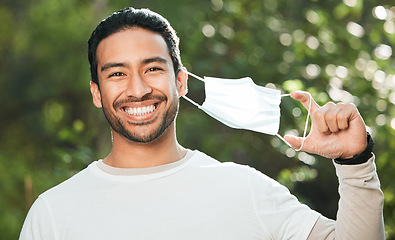 Image showing Portrait, mask and remove with a man breathing fresh air in nature, feeling happy at the end of restrictions. Covid, freedom and smile for post lockdown with a young person in the forest or woods