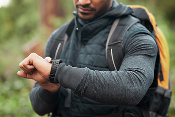 Image showing Hand, watch and a man hiking in the forest closeup for freedom, travel or adventure outdoor in nature. Time, fitness and recreation with a hiker in the woods to discover or explore the wilderness