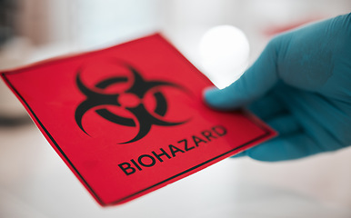 Image showing Hand, science and a sign for biohazard in a laboratory to label a chemical for safety warning or danger. Healthcare, medical and biology with a scientist closeup in a lab for research or innovation