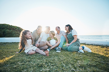 Image showing Family, grandparents and children on grass by ocean for bonding, relationship and relax together. Nature, parents and happy grandmother, grandfather and kids on holiday, vacation and travel by sea