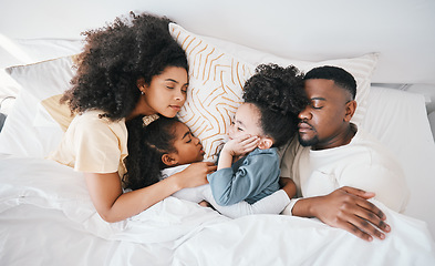 Image showing Mom, dad and kids in bed, sleeping and top view for care, hug and relax together on holiday in family home. Mother, father and tired children for bonding, love or rest in bedroom for fatigue in house