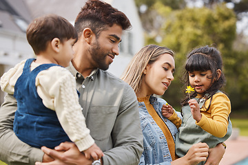 Image showing Mother, father and children outdoor with a flower in spring with love, care and security. A man, woman or parents and kids together in a family backyard to relax while bonding on holiday or vacation