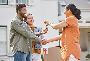 Image showing Keys, realtor handshake and couple moving to new house, property investment and mortgage success, deal or thank you. Young people shaking hands and giving lock to dream home and real estate agreement