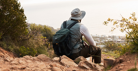 Image showing Back, relax and view with a black man hiking in the mountains for travel, freedom or adventure in a remote location. Hike, break and scenic with a backpacker or hiker outdoor in nature to explore