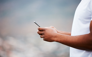 Image showing Fitness, hands and man with phone outdoor for social media, text or update on blurred background. Smartphone, zoom and guy athlete with app for training progress, internet or location, search or blog