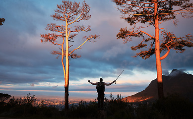 Image showing Dark, morning and person on the mountain for hiking, fitness or trekking for vacation. Back, nature and a traveler in the forest or woods for exercise, adventure or walking in the scenery with a view