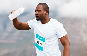 Image showing Outdoor, water bottle and black man with fitness, marathon and exhausted with exercise, workout and wet. African person, runner and athlete rest, thirsty and health with break, liquid and training