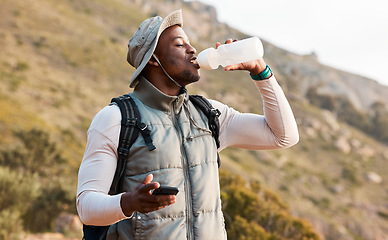 Image showing Hiking, water bottle and black man with a smartphone, connection and hydration with fitness. African person, guy or hiker with a cellphone, mountain or thirsty with health, network or drinking liquid