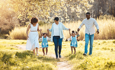 Image showing Walking, holding hands and family generations in nature at an outdoor park together for bonding. Love, fun and children with grandmother and parents in a green garden on weekend trip or holiday.