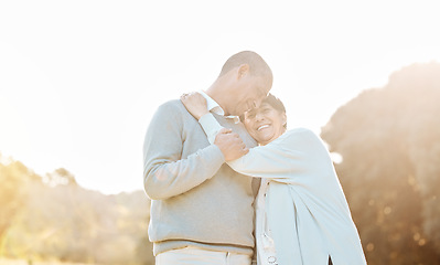 Image showing Nature, sunset and senior couple hugging, laughing and bonding on a romantic date in a park. Happy, smile and elderly woman and man in retirement embracing with love, care and happiness in a field.