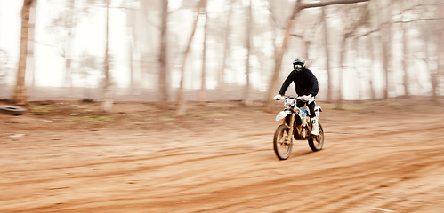 Image showing Motorcycle, speed and space with a sports man in the forest for adrenaline while dirt biking. Bike, training and power with a person driving fast on an off road course for freedom or performance