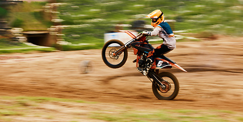 Image showing Motorcycle, balance and motion blur with a man at a race on space in the forest for dirt biking. Bike, fitness and power with a sports person driving fast on an off road course for freedom or speed