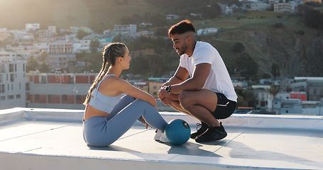 Image showing Fitness, couple and outdoor to talk and rest for exercise, workout or training together on a city rooftop. Happy man and woman on sports break with medicine ball, communication and coach in Cape Town