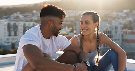 Image showing Fitness, rest and couple outdoor for exercise, workout or training together on a city building rooftop. Happy man and woman on break with smile, communication or conversation for health and wellness