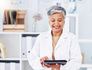 Image showing Tablet, doctor and smile of woman in clinic for online healthcare management, hospital software and research. Mature medical professional with digital technology for telehealth, data review and app