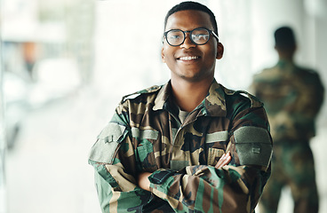 Image showing Confident soldier portrait, smile and arms crossed in army building, pride and professional hero service. Military career, security and courage, black man in camouflage uniform at government agency.