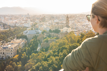 Image showing Bolnde female touris enjoying amazing panoramic aerial view of Malaga city historic center, Coste del Sol, Andalucia, Spain.