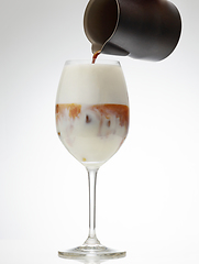 Image showing coffee espresso pouring into glass of iced milk